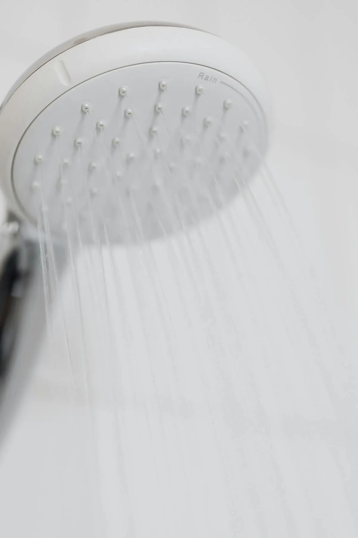 Limescale buildup on a South Florida bathroom faucet next to a water softener tank